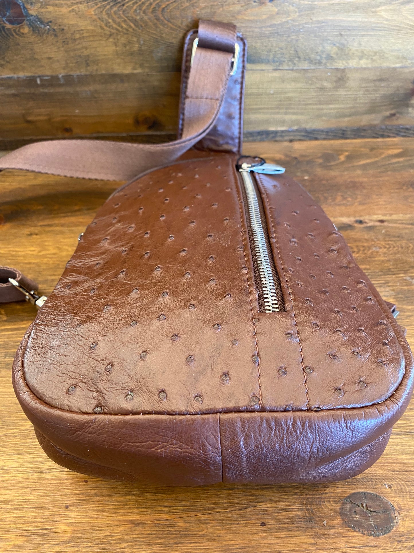 Brown ostrich sling bag. / Bolso avestruz