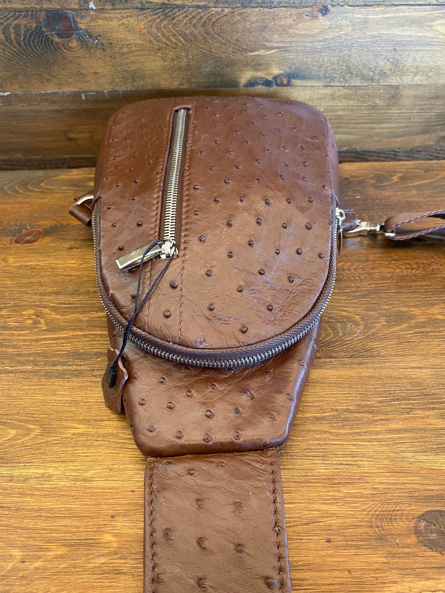 Brown ostrich sling bag. / Bolso avestruz