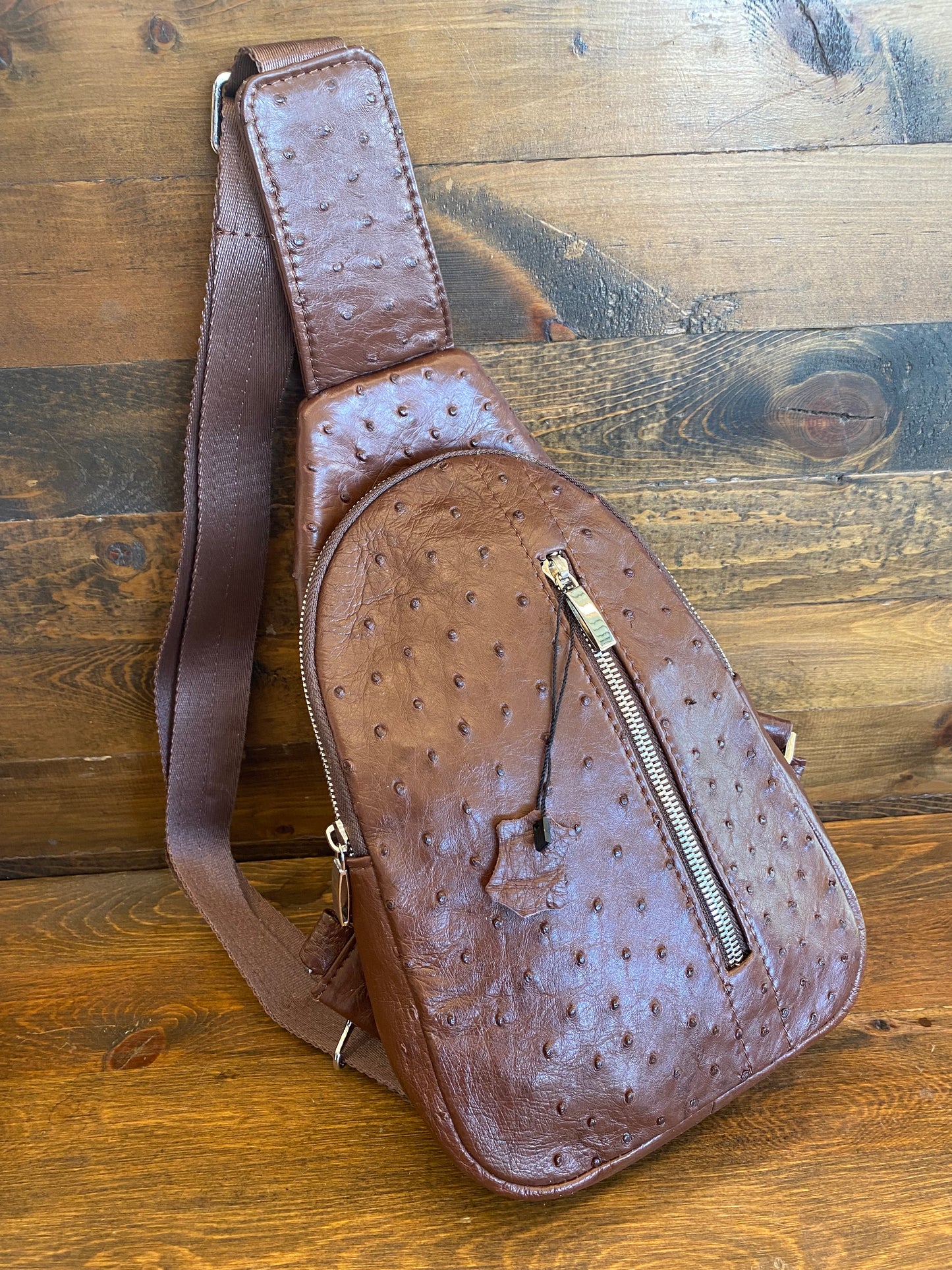 Brown ostrich sling bag. / Bolso avestruz
